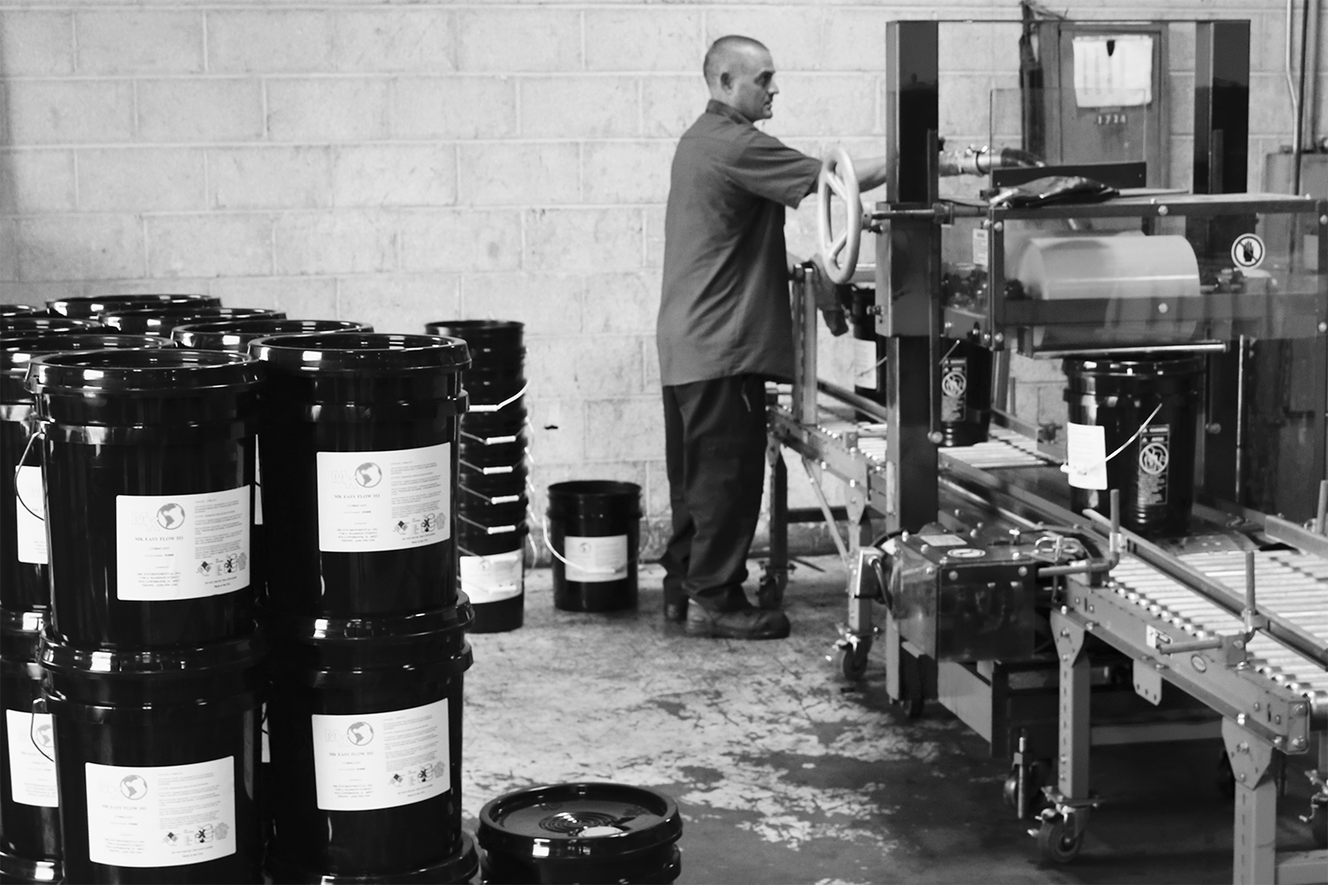 Worker operating pail filling equipment at Leahy-Wolf facility